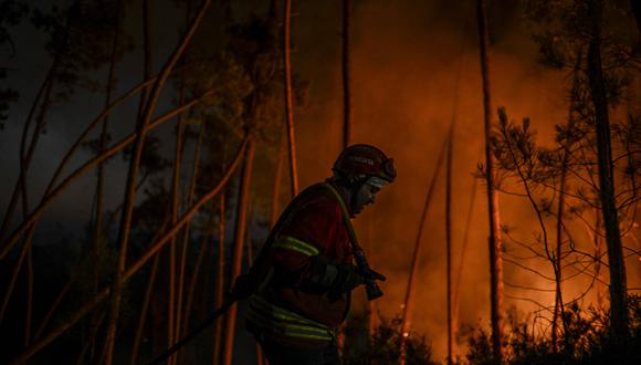 Un bombero trabaja para extinguir un incendio forestal en Casais do Vento en Alvaiazere el 10 de julio de 2022.  (Foto por PATRICIA DE MELO MOREIRA / AFP)