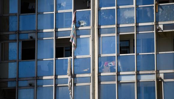 Se ven sábanas atadas y utilizadas para escapar colgando de las ventanas después de que tres personas murieran en un incendio en un edificio en Marsella, Francia, el 17 de julio de 2021. (CLEMENT MAHOUDEAU / AFP).