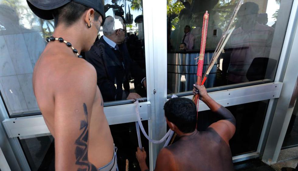 Indígenas bloquean la puerta de salida del Ministerio de Justicia durante una protesta realizada en Brasilia. Ellos demandan que se discuta la legislación que protege la amazonía. (AP)