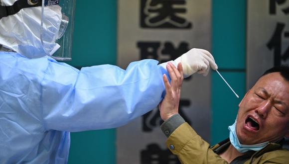 En esta foto de archivo tomada el 16 de abril de 2020, un hombre es sometido a un examen para detectar el nuevo coronavirus COVID-19 en Wuhan, China. (Foto de Hector RETAMAL / AFP).