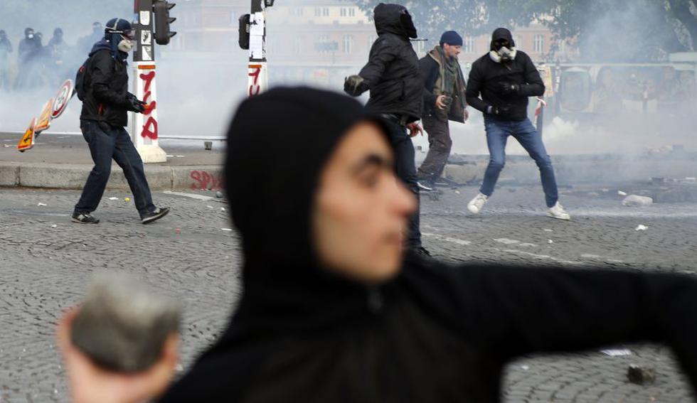 Manifestante arroja piedras durante la tradicional marcha de 1 de mayo en París. ()