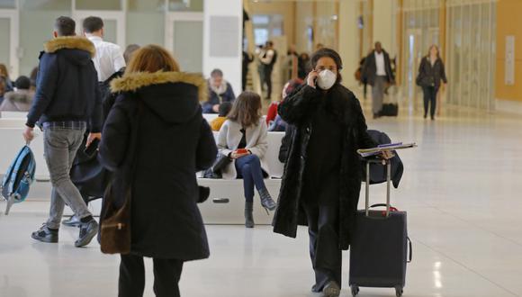 Una mujer que usa una máscara como precaución contra el nuevo coronavirus camina en el juzgado de París. (Foto: AP)