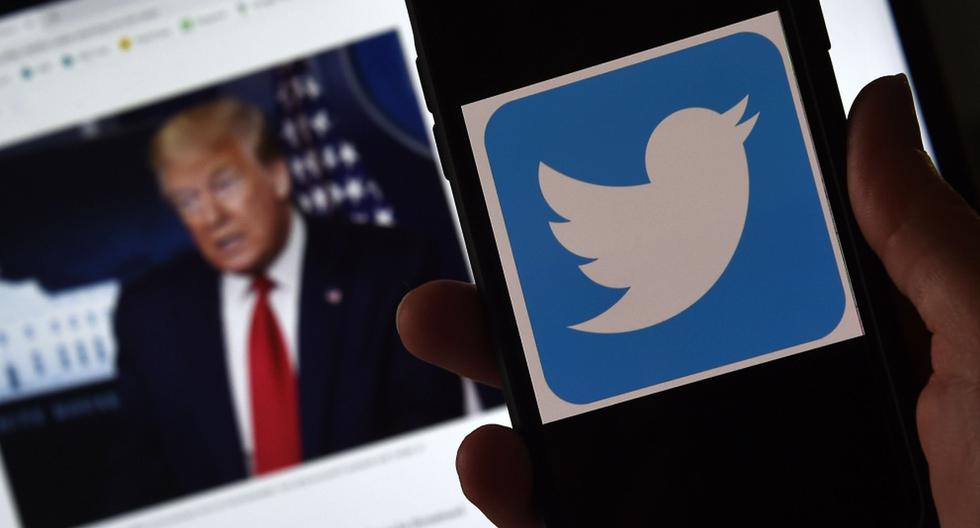 En esta ilustración fotográfica, se muestra un logotipo de Twitter en un teléfono móvil con la imagen del presidente Donald Trump en el fondo. (AFP / Olivier DOULIERY).