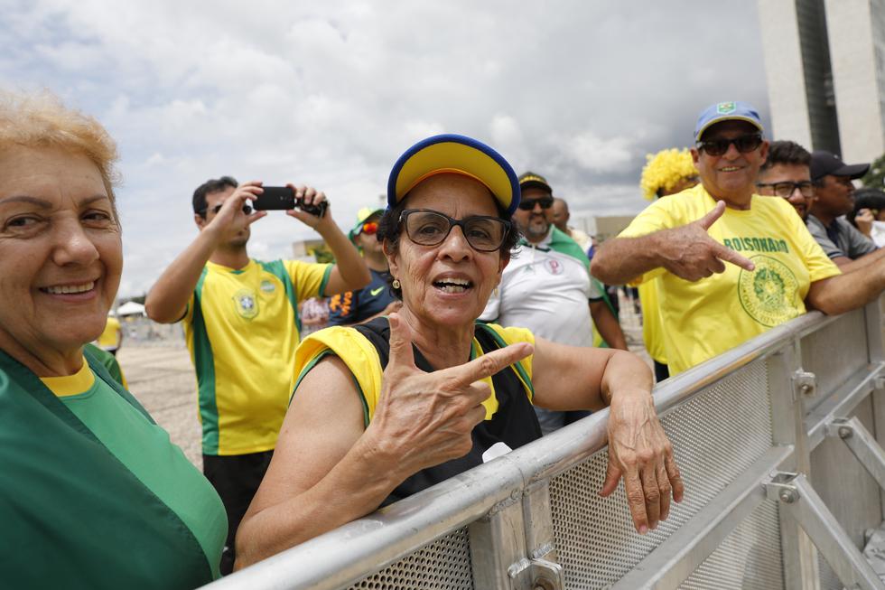 FOTO 1 | Los simpatizantes de Jair Bolsonaro llenaron las calles de Brasilia. En la foto, una mujer emula su seña con los dedos. (Foto: AP)