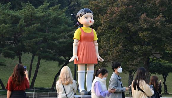 Visitantes se reúnen frente a un modelo de la muñeca llamada 'Younghee', que aparece en la serie de Netflix "Squid Game", que se exhibe en un parque en Seúl el 26 de octubre de 2021. (Foto: Jung Yeon-je / AFP)