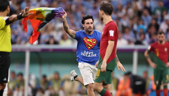 Una persona ingresa al campo de juego con la bandera LGTBI durante el encuentro entre Uruguay y Portugal.

Foto: Daniel Apuy / @photo.gec