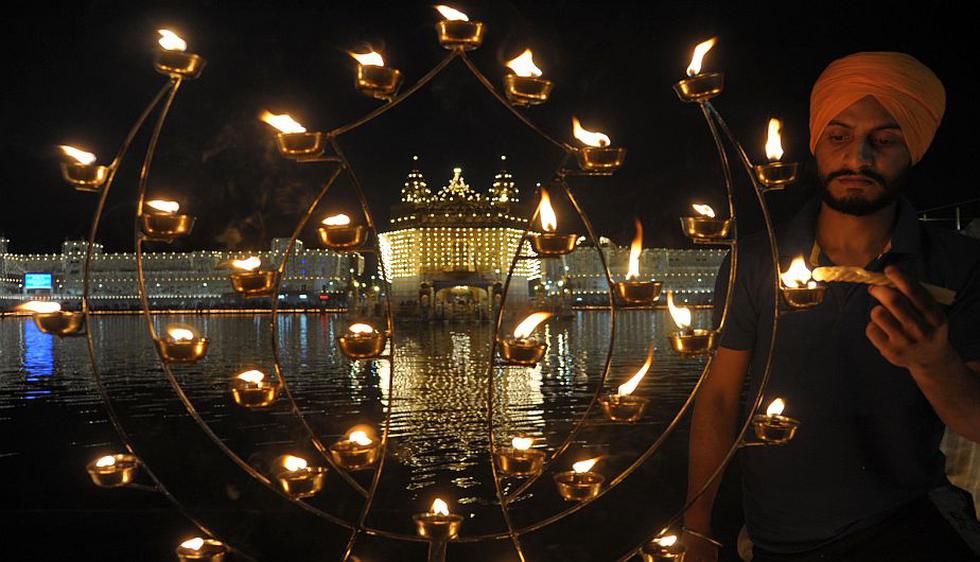 Un Sikh enciende luces delante del templo dorado de Amritsar, India. (AFP)