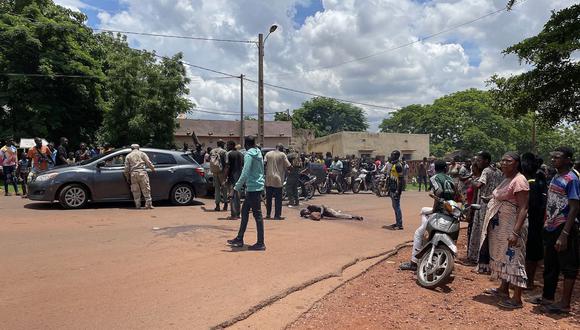Contenido gráfico / Una multitud se reúne alrededor de un hombre (no visto) sospechoso de participar en un ataque "terrorista" frustrado después de ser golpeado por una multitud, frente a la base militar en Kati, Malí, el 22 de julio de 2022. (Foto por AFP)