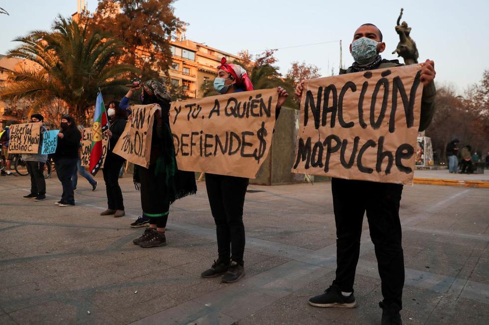 Los activistas sostienen pancartas que dicen "Y tú, ¿a quién estás defendiendo?" y "Nación Mapuche" durante una protesta en apoyo a los miembros de las comunidades mapuche encarcelados y en huelga de hambre, en Santiago de Chile. (REUTERS/Ivan Alvarado).