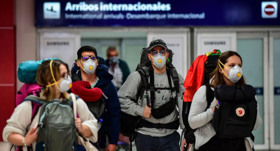 Imagen referencial. Pasajeros con mascarilla como medida preventiva contra la propagación del coronavirus COVID-19 arriban al Aeropuerto Internacional de Ezeiza en Buenos Aires, el 12 de marzo de 2020.  (AFP / Ronaldo SCHEMIDT).