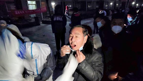 Esta foto tomada el 8 de enero de 2022 muestra a residentes haciendo cola para someterse a pruebas de ácido nucleico para detectar el coronavirus en el condado de Huaxian, ciudad de Anyang. (Foto de AFP)