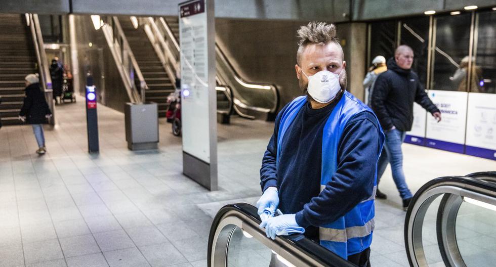Imagen referencial. Un trabajador limpia y desinfecta una escalera mecánica en una estación de metro de  Copenhague, Dinamarca. (Olafur Steinar Gestsson / Ritzau Scanpix / AFP).