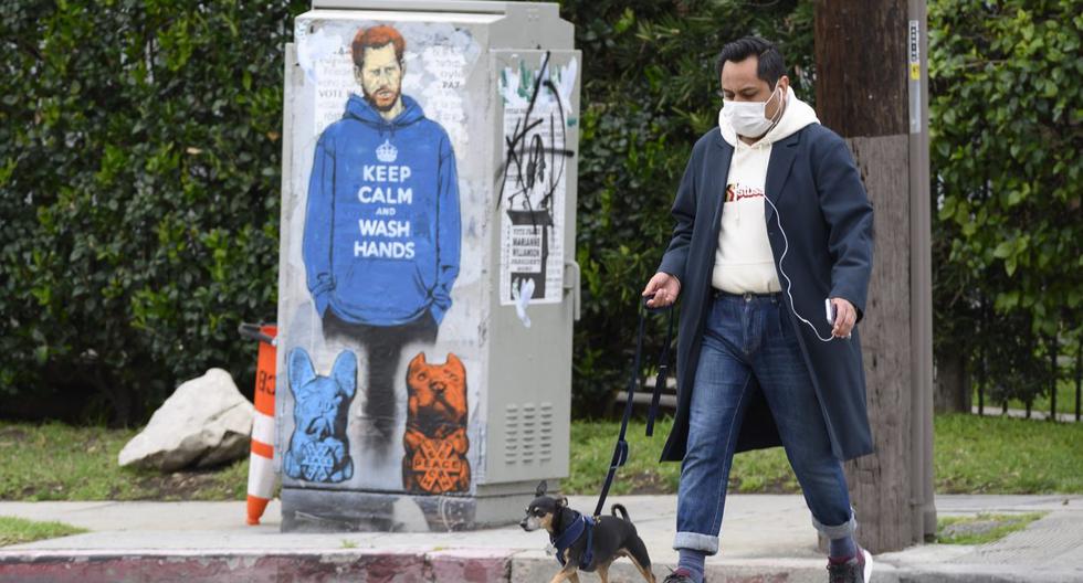 Una persona con mascarilla es vista paseando a su perro en las calles de Los Ángeles, California. Imagen del 7 de abril de 2020. (Robyn Beck / AFP).