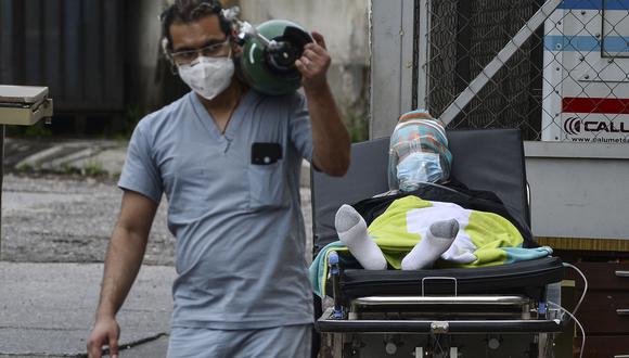 Un médico lleva un tanque de oxígeno después de desconectar a un hombre infectado con coronavirus (COVID-19) en un hospital de campaña establecido en el patio del Hospital Escolar de Tegucigalpa. (Foto: Orlando Sierra / AFP)