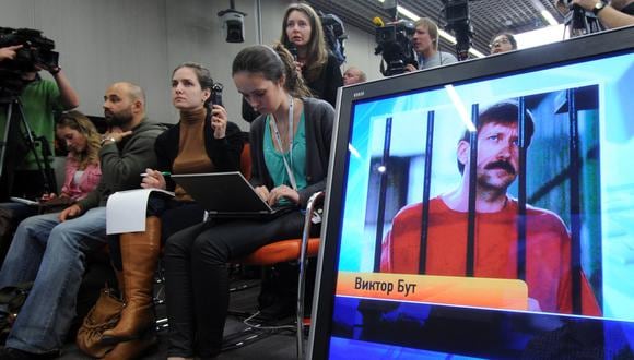 Los periodistas se sientan cerca de una pantalla que muestra al contrabandista de armas ruso condenado Viktor Bout en Moscú, el 12 de abril de 2012, durante una teleconferencia con Bout desde su prisión estadounidense. (Foto de KIRILL KUDRYAVTSEV / AFP)