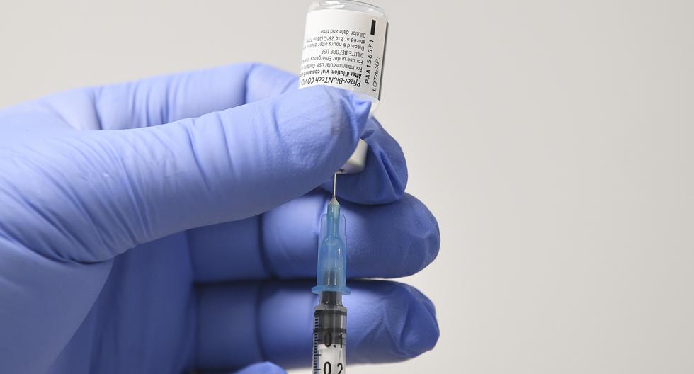 Imagen referencial. Un miembro del personal utiliza una aguja y un frasco de la vacuna Pfizer-BioNTech COVID-19 para preparar una dosis en un centro de salud en Cardiff, Gales del Sur, el 8 de diciembre de 2020. (JUSTIN TALLIS / various sources / AFP).