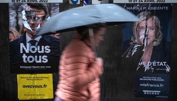 Los peatones pasan frente a los carteles de campaña del presidente francés y candidato Emmanuel Macron y la candidata Marine Le Pen en Eguisheim, este de Francia. (Foto:   JOEL SAGET / AFP)