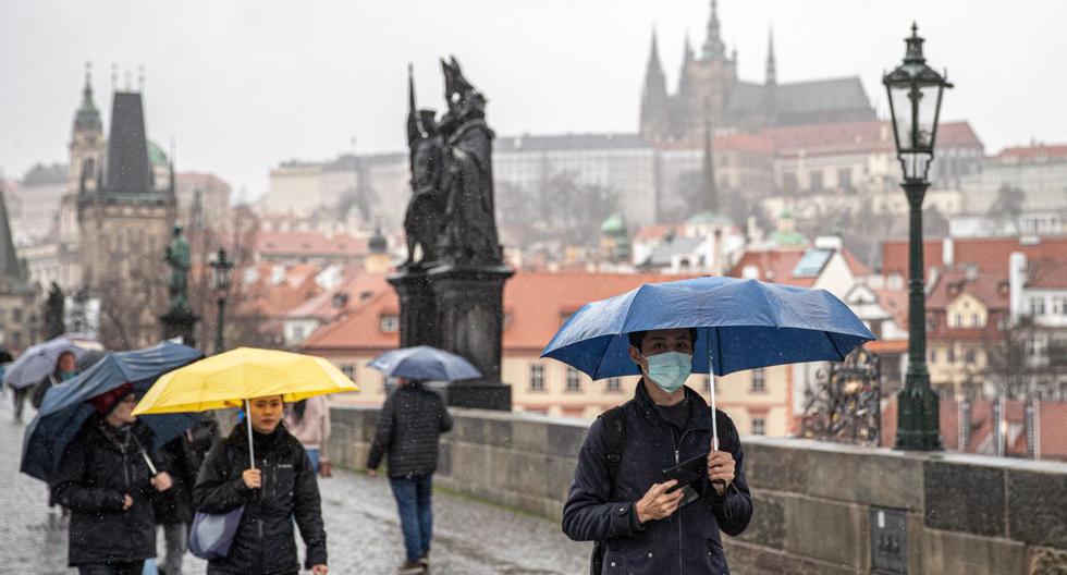 Un turista con una máscara camina por el Puente de Carlos en Praga, República Checa, el 11 de marzo de 2020.  (AFP).