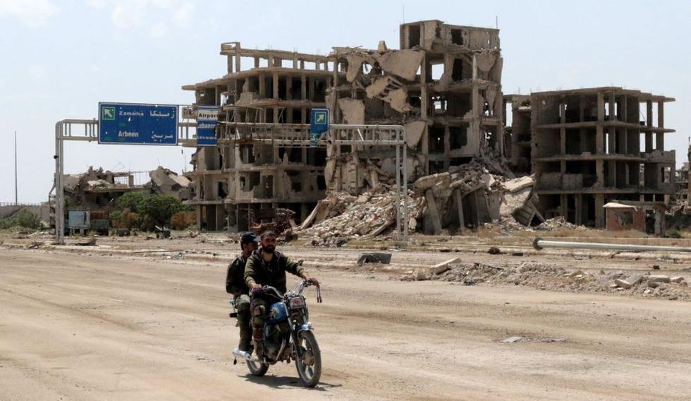 Dos hombres viajan en bicicleta en Damasco, recientemente recuperada por el régimen de Al Asad. (EFE)