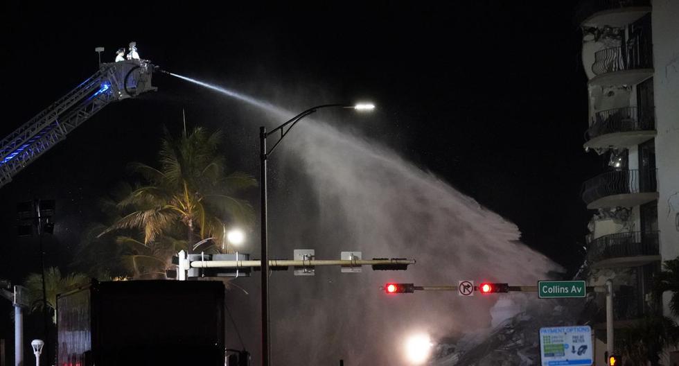 Un equipo de bomberos de Miami-Dade rocía agua sobre los escombros mientras continúan los esfuerzos de rescate donde un ala de un edificio de condominios frente a la playa de 12 pisos se derrumbó, el jueves 24 de junio de 2021 en el área de Surfside de Miami. (AP/Gerald Herbert).