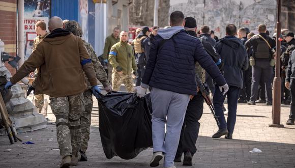Los soldados ucranianos recogen los cuerpos después de que un ataque con cohetes mató al menos a 50 personas el 8 de abril de 2022 en una estación de tren en Kramatorsk, al este de Ucrania. (Foto de FADEL SENNA / AFP)