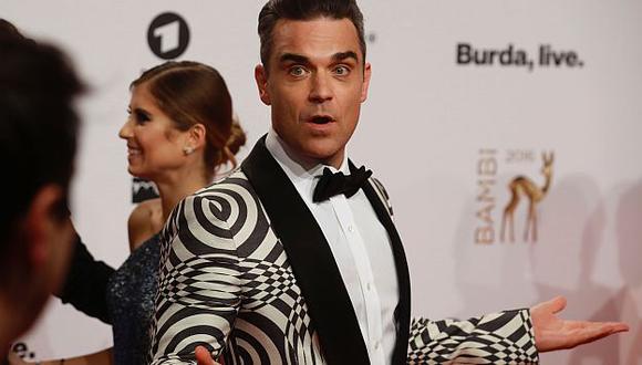 Robbie Williams se desinfectó las manos con gel luego de saludar a sus fans. (AFP)