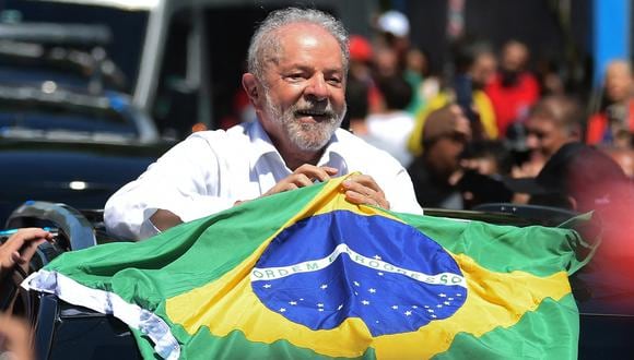 Luiz Inácio Lula da Silva sostiene una bandera brasileña al salir de un colegio electoral durante la segunda vuelta de las elecciones presidenciales en Sao Paulo, Brasil, el 30 de octubre de 2022. (Foto de CARL DE SOUZA / AFP)