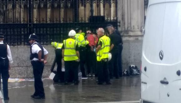 La policía detiene a un hombre, que se ha empapado en lo que parecía ser un líquido inflamable, fuera de la puerta del Parlamento en Londres. (Foto: Reuters)