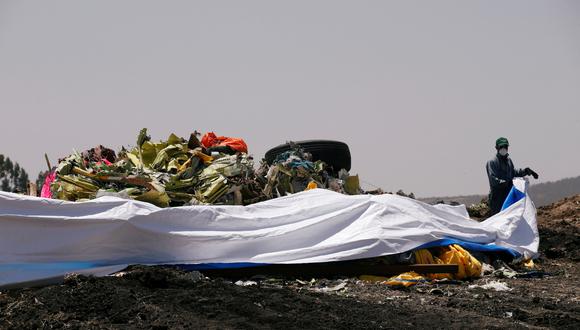 Un hombre cubre los restos del accidente de Ethiopian Airlines. (Foto: Reuters)