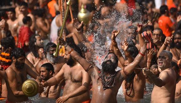 Hombres santos indios, o Naga Sadhu, junto con los demás peregrinos se bañan en el río Ganges durante el Kumbh Mela en Haridwar, Uttarakhand, India, el 14 de abril de 2021, en medio de la pandemia de coronavirus. (EFE / EPA / IDREES MOHAMMED).
