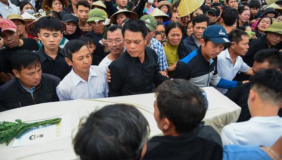 Una multitud observa a los familiares que llevan el ataúd de Nguyen Van Hung, mientras llega al distrito de Dien Chau, provincia de Nghe An. (AFP)
