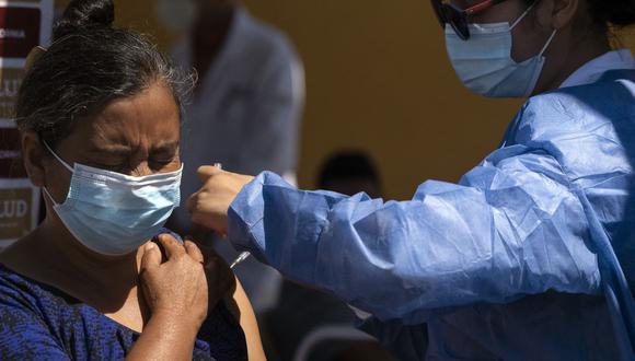 Una solicitante de asilo que acampa en el puerto de cruce de El Chaparral es vacunado contra el COVID-19 en Tijuana, estado de Baja California, México, en la frontera con los Estados Unidos, el 3 de agosto de 2021. (Guillermo Arias / AFP).