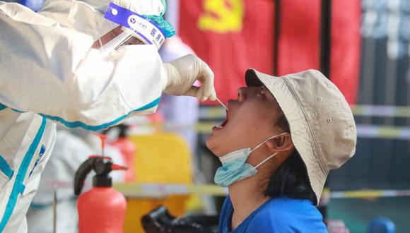 Esta foto tomada el 1 de agosto de 2021 muestra a una persona siendo sometida a la prueba de coronavirus covid-19 en Yangzhou, en la provincia oriental de Jiangsu, en China. (Foto de STR / AFP).