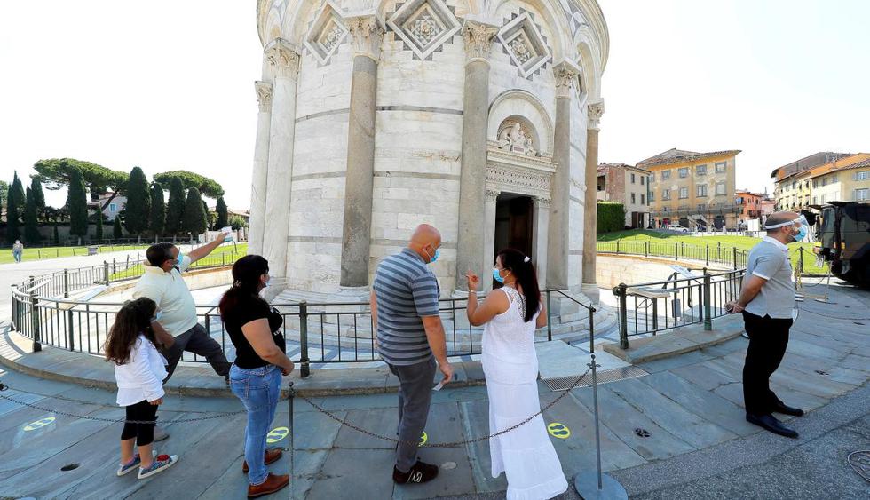 Un pequeño grupo de ciudadanos esperan para entrar a la Torre de Pisa en Italia después de que se cerró para evitar la propagación del nuevo coronavirus. (EFE/EPA/FABIO MUZZI)