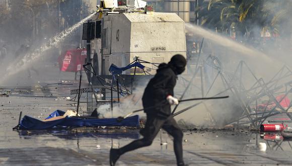 La policía antidisturbios dispersa a los manifestantes con un cañón de agua durante los enfrentamientos posteriores a la marcha del Primero de Mayo en Santiago el 1 de mayo de 2022. (Foto de Martin BERNETTI / AFP)