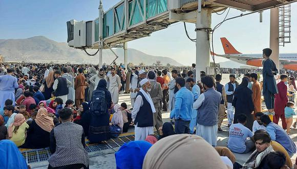 Los afganos se agolpan en la pista del aeropuerto de Kabul el 16 de agosto de 2021 para huir del país, ya que los talibanes controlaban Afganistán después de que el presidente Ashraf Ghani huyera del país y admitiera que los insurgentes habían ganado la guerra de 20 años. (AFP)