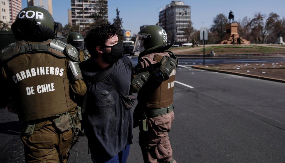 Un manifestante es detenido por Fuerzas Especiales de Carabineros este viernes durante una pequeña concentración en la Plaza Italia de Santiago. (EFE/Alberto Valdés).