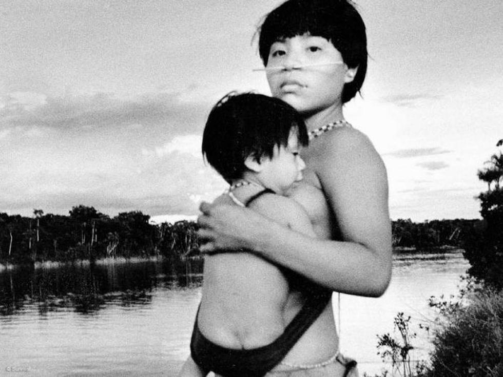Una mujer yanomami carga a su hijo en la ribera de un río amazónico. (Steve Cox/Survival)