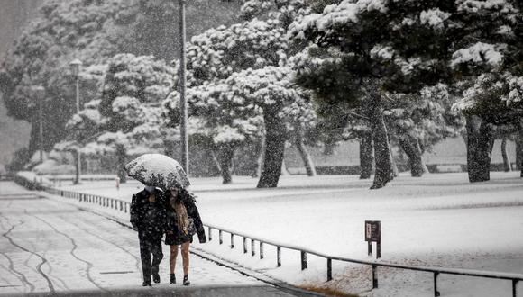 La gente camina por un pavimento cubierto de nieve en Tokio el 6 de enero de 2022. (Foto: Behrouz MEHRI / AFP)