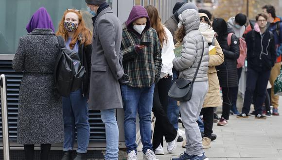 La gente espera en una cola fuera del centro de vacunación del University College London Hospital para recibir la vacuna Covid-19 o el refuerzo en Londres el 17 de diciembre de 2021. (Foto: Tolga Akmen / AFP)