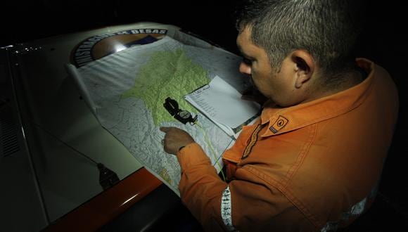 Un miembro de Protección Civil, parte de un grupo de rescatistas, marca un punto en un mapa donde pretenden iniciar un operativo de búsqueda de miembros de un grupo religioso que continúan desaparecidos en San Cristóbal, estado Táchira, Venezuela, el 6 de septiembre de 2022. (Foto por JOHNNY PARRA / AFP)