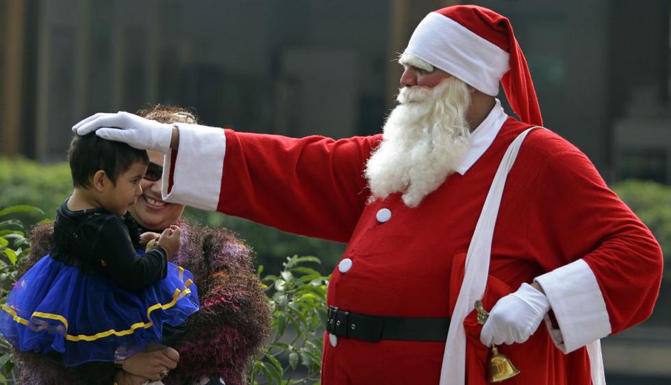 Papá Noel saluda a una niña en Bangladesh. (AP)