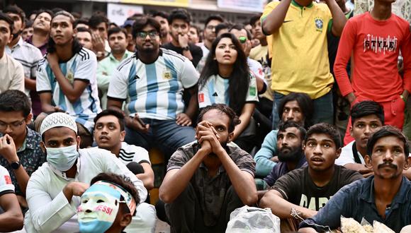 Los fanáticos del fútbol ven el partido de fútbol del Grupo C de la Copa Mundial de Qatar 2022 entre Argentina y Arabia Saudita en una pantalla grande, en Dhaka (Bangladesh), el 22 de noviembre de 2022. (Foto de Munir uz zaman / AFP)