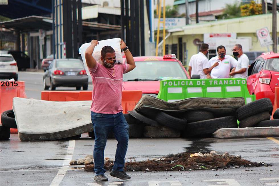Un hombre cruza hoy una barrera en un puesto fronterizo entre Panamá y Costa Rica, que se encuentra bloqueado dadas las manifestaciones de ciudadanos costarricenses contra un eventual acuerdo del Gobierno de Carlos Alvarado con el Fondo Monetario Internacional (FMI), en Paso Canoas (Panamá). (Foto: EFE/Marcelino Rosario)