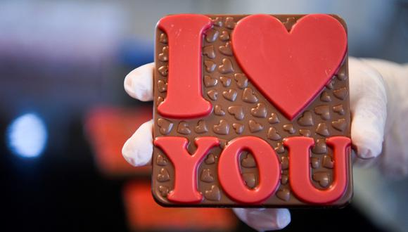 A worker holds a freshly made chocolate at the "Amel" handcrafted chocolate factory near Pristina on February 12, 2022, ahead of Valentine's Day -  with chocolate one of the most popular gifts each February 14. (Photo by Armend NIMANI / AFP)