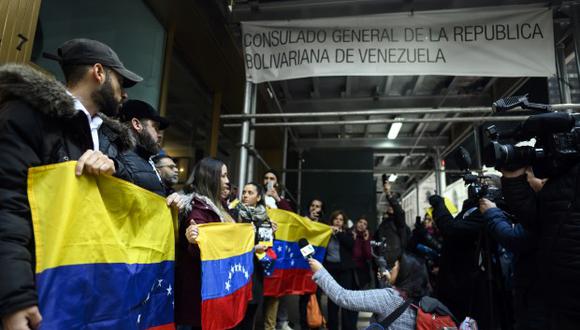 Los partidarios del autoproclamado presidente venezolano Juan Guaido, sostienen banderas frente al consulado venezolano en Nueva York el 19 de marzo de 2019 en la ciudad de Nueva York. (Fotot: AFP)