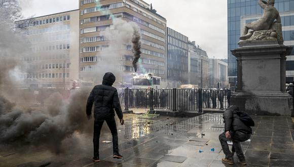 Un manifestante se para frente a las fuerzas policiales durante una manifestación por la "libertad, la democracia y los derechos humanos" organizada por la alianza Europeos Unidos en Bruselas. (Foto: HATIM KAGHAT / Belga / AFP)