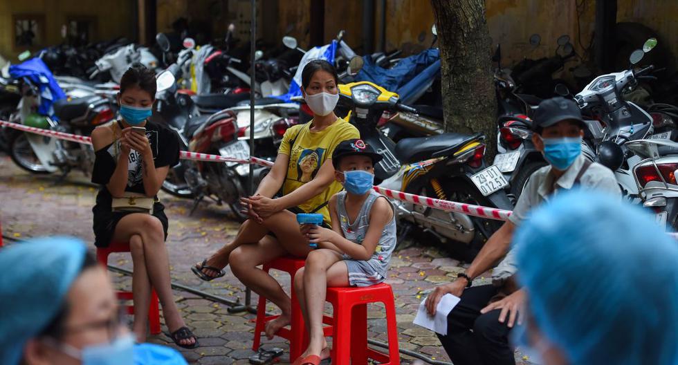 Los residentes que usan máscaras faciales esperan la prueba del coronavirus en un centro médico del distrito de Hoan Kiem, en Hanoi (Vietnam), el 13 de agosto de 2020. (Nhac NGUYEN / AFP).