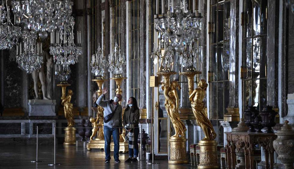 La gente visita la Galerie des Glaces (Salón de los Espejos) en el emblemático Palacio de Versalles (Francia). (AFP / Anne-Christine POUJOULAT).