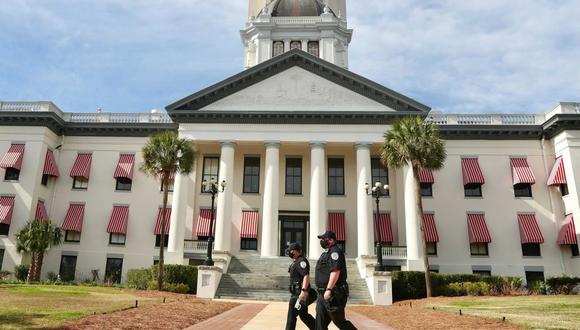 Dos policías del capitolio caminan frente al Capitolio del Estado de Florida en Tallahassee, Florida, con esposas flexibles el domingo 17 de enero de 2021 (Amy Beth Bennett / South Florida Sun-Sentinel vía AP).